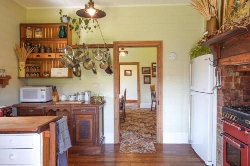 a kitchen with a counter top and a refrigerator at Casilda House-Central Waterfront in Dunalley