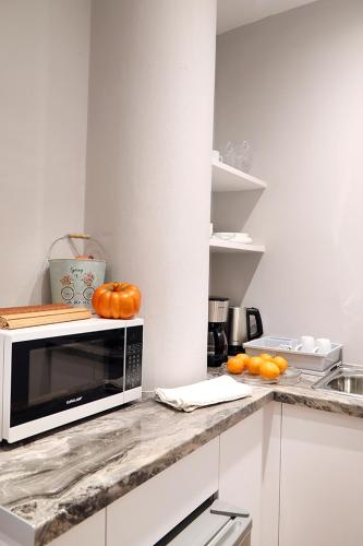 a kitchen with a microwave and pumpkins on a counter at My Athens House in Athens
