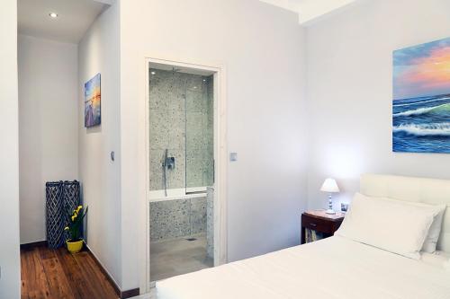 a white bedroom with a shower and a bed at My Athens House in Athens