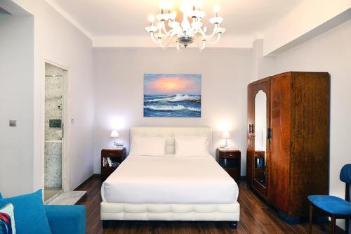 a bedroom with a white bed and a chandelier at My Athens House in Athens