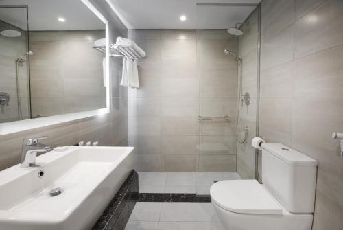 a white bathroom with a sink and a toilet at Pyramisa Suites Hotel Cairo in Cairo