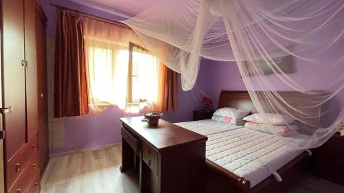 a bedroom with a bed with a mosquito net at Happy Home in Lastva