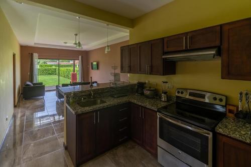 a kitchen with wooden cabinets and granite counter tops at Casa vacacional Tamarindo beach in Guatemala