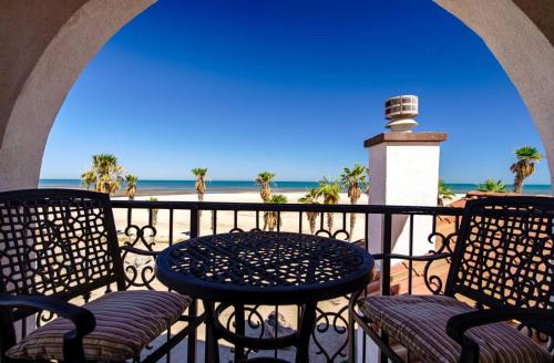 a table and chairs on a balcony with a lighthouse at Condo76-4 The STAR OF THE SEA - EL DORADO RANCH SAN FELIPE BEACH RENTAL in La Ponderosa