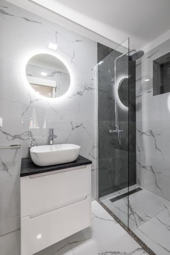 a white bathroom with a sink and a shower at Villa Perkov private pool in Kaštela