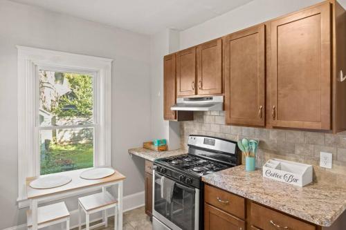 a kitchen with wooden cabinets and a stove top oven at Beautiful One Bed in Lovely Park Ave Neighborhood in Rochester
