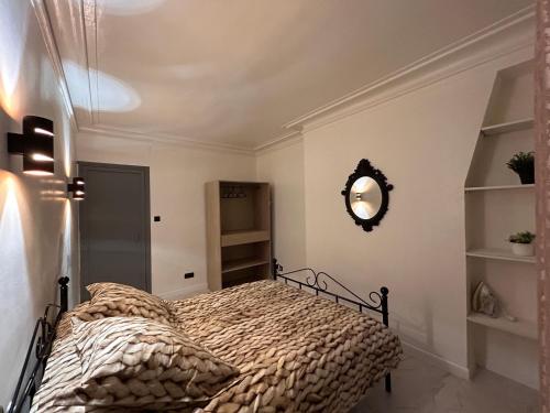 une chambre avec un lit et un miroir au mur dans l'établissement Appartement Paris, à Paris