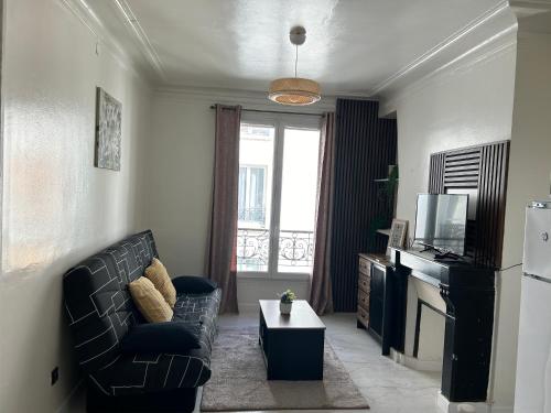 un salon avec un canapé et une télévision dans l'établissement Appartement Paris, à Paris