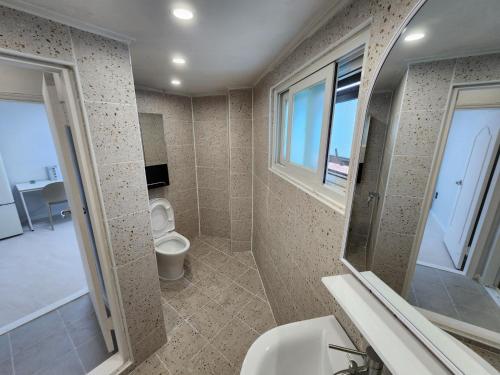 un bagno con un water, un lavandino e una finestra di Goyo Stay a Uijeongbu