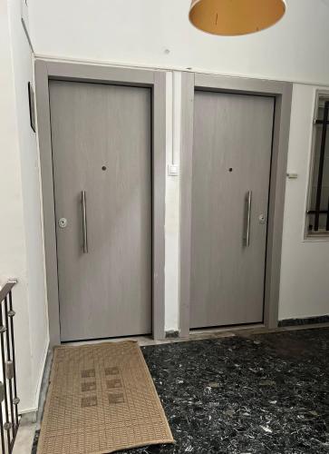 two garage doors in a room with a rug at Jr Apartments 3 in Athens