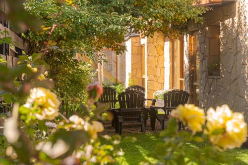 a group of chairs sitting next to a building at Hotel Antiguos in San Martín de los Andes