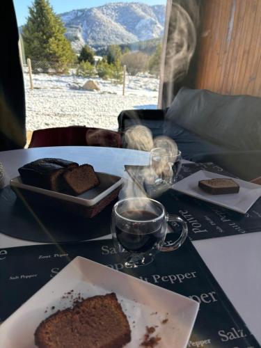 ein Tisch mit einem Teller Brot und einer Tasse Kaffee in der Unterkunft Cabaña - 5to Rincon Meliquina Home in Villa Meliquina