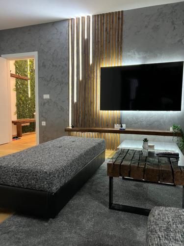 a bedroom with a bed and a flat screen tv at LiboroApartments in Niš