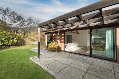 dom z dużą przeszkloną przybudówką, w tle góry w obiekcie Skye Scape Luxury Retreat - Mountain Views w mieście Frankton