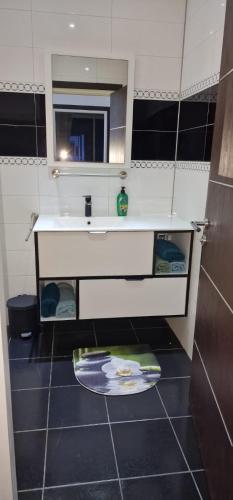 a small bathroom with a sink and a mirror at Luxus Apartments in Kelibia