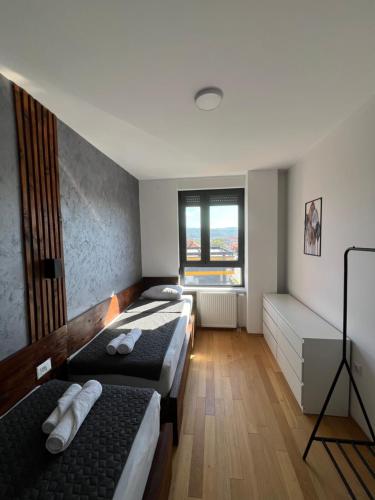 a room with three beds and a window at LiboroApartments in Niš