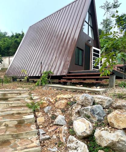 a house with a metal roof and some rocks at Heaven77 in Ban Sap Phrik