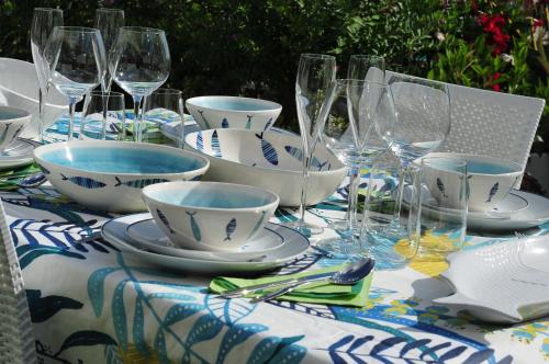 a table with glasses and bowls and plates on it at Appartamento Rapallo Sky Garden Maria Jose Liguria - Attico vista mare - Terraces - 2 bagni- 2 Camera da Letto - Box, Wi-fi, Idromassaggio Free inteiro Attico per Voi, con Ascensore in Rapallo