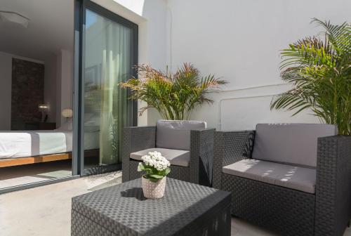 a patio with two chairs and a table with flowers at Hotel Nou Romà in Denia