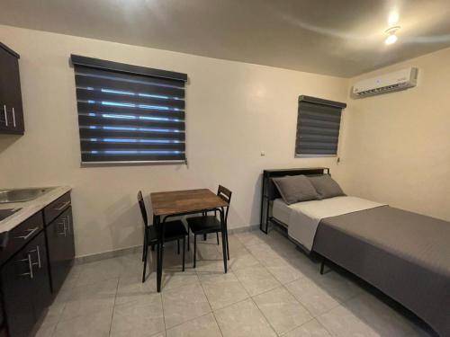 a bedroom with a bed and a table and a bed and a desk at Estudios OM in Magdalena de Kino