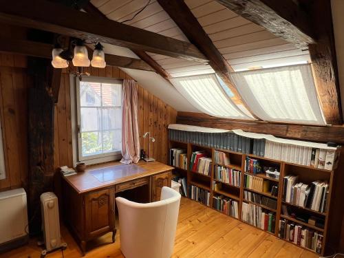 an attic room with a desk and bookshelves at Namibian Sun - Seehaus in Stäfa