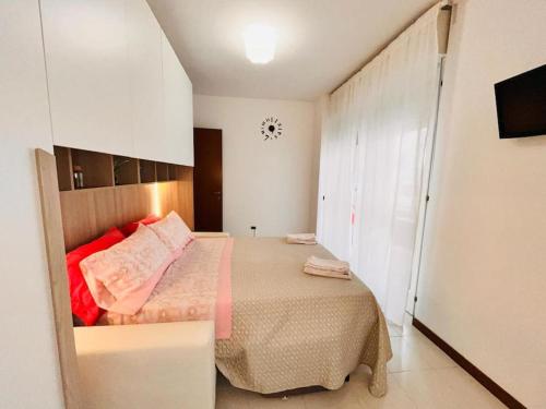 a small bedroom with a bed and a clock on the wall at Happy House2 - 7 minuti da MXP e 30 minuti da Milano in Busto Arsizio