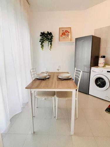 a kitchen with a table with chairs and a refrigerator at Happy House2 - 7 minuti da MXP e 30 minuti da Milano in Busto Arsizio