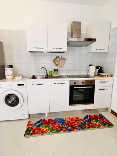 a kitchen with a counter with flowers on the floor at Happy House2 - 7 minuti da MXP e 30 minuti da Milano in Busto Arsizio