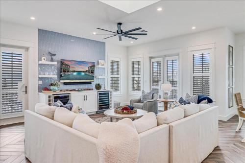 a living room with white furniture and a ceiling fan at Seashells to Sandcastles 156 BAR in Mustang Beach