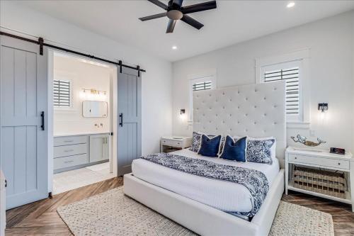 a white bedroom with a large bed with blue pillows at Seashells to Sandcastles 156 BAR in Mustang Beach