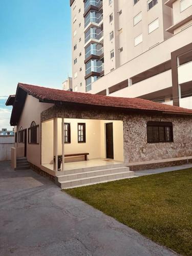 a small building in front of a tall building at Casa em Imbituba in Imbituba