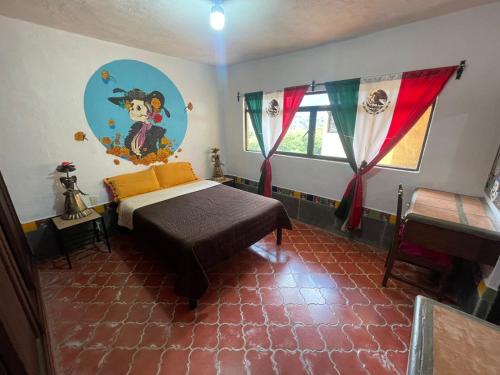 Un dormitorio con una cama y un cuadro en la pared. en Hostal Casa de Dante, en Guanajuato