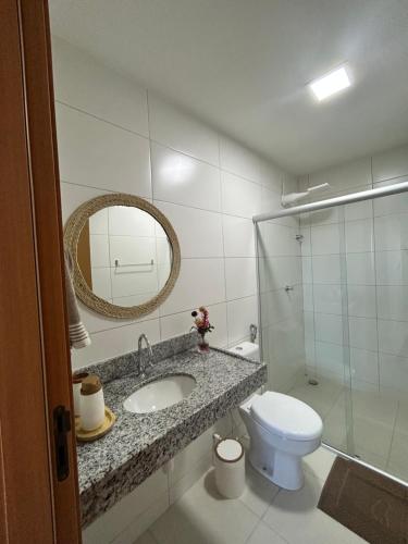 a bathroom with a sink and a toilet and a mirror at Barra beach in Barra de São Miguel