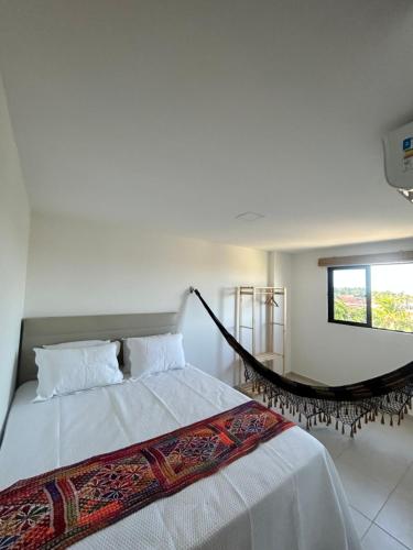 a bedroom with a bed and a hammock at Barra beach in Barra de São Miguel
