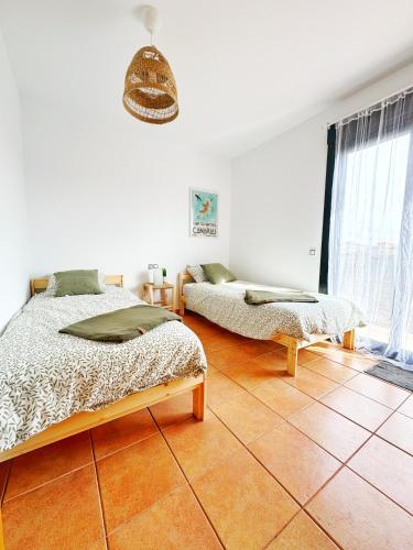 a bedroom with two beds on a tiled floor at Casa Bali in Majanicho