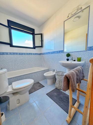 a bathroom with a toilet and a sink and a tub at Casa Bali in Majanicho