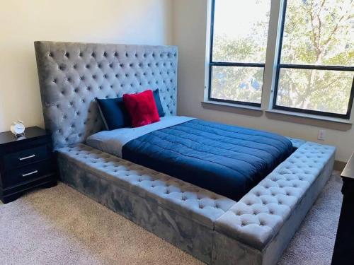 a large bed with a blue blanket on it in a bedroom at Houston Midtown Luxury in Houston