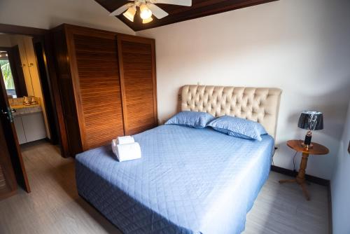 a bedroom with a bed with a blue comforter at Apartamento no Centro de Búzios in Búzios
