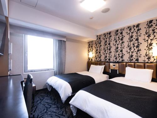 Postel nebo postele na pokoji v ubytování APA Hotel Nagoya Sakae