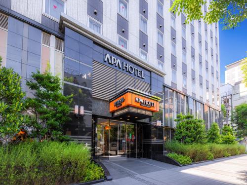 a hotel building with a sign on the front of it at APA Hotel Nagoya Sakae in Nagoya
