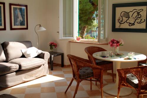ein Wohnzimmer mit einem Sofa, einem Tisch und Stühlen in der Unterkunft Darsena Apartments in Savona