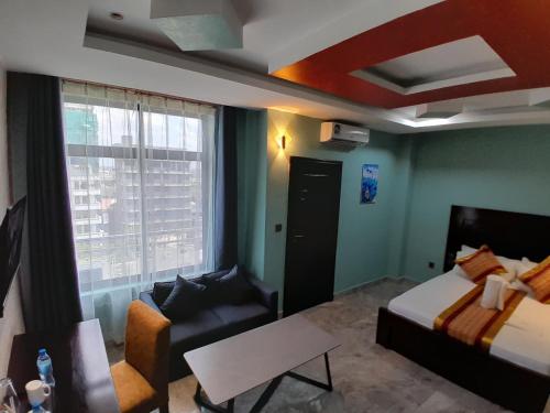 a hotel room with a bed and a couch at Mazola Diamond Hotel in Dar es Salaam