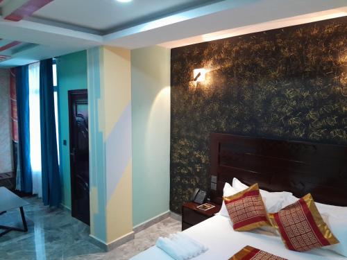 a hotel room with a bed and a wall at Mazola Diamond Hotel in Dar es Salaam