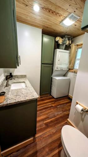 a small kitchen with a sink and a refrigerator at River Retreat Cabin - Living Water Farm in Cleveland