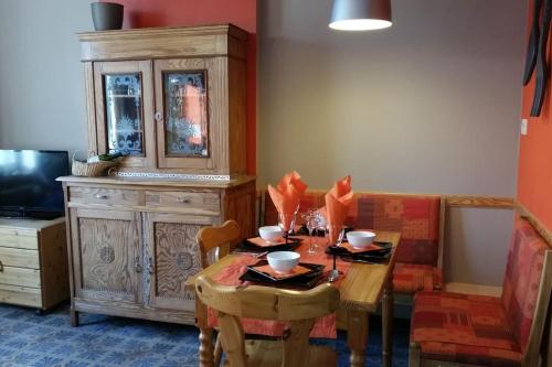 a dining room with a table and a wooden cabinet at Appartement centre-ville - gîte urbain avec jardin in Bastogne