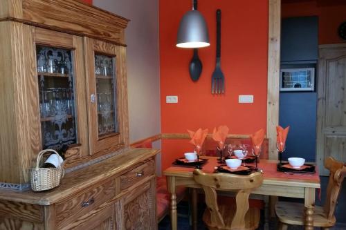 a dining room with a table and a wooden cabinet at Appartement centre-ville - gîte urbain avec jardin in Bastogne