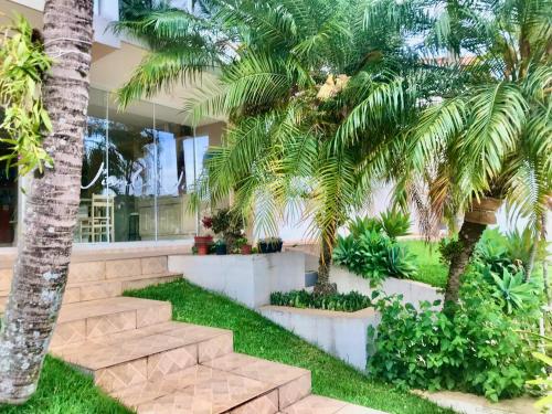a house with palm trees and stairs in front of it at Casa de Temporada Magnífica II com piscina in Atibaia