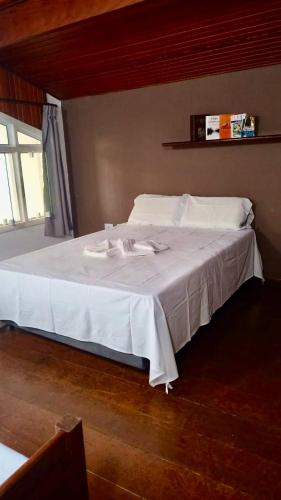 a large white bed in a room with a window at Casa de Temporada Magnífica II com piscina in Atibaia