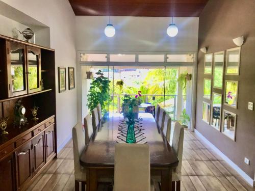 a dining room with a long table and chairs at Casa de Temporada Magnífica II com piscina in Atibaia