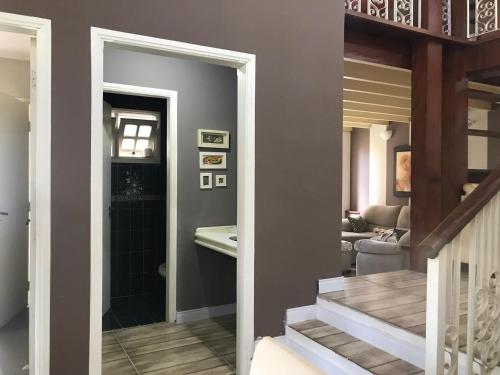 a hallway with a staircase leading to a living room at Casa de Temporada Magnífica II com piscina in Atibaia